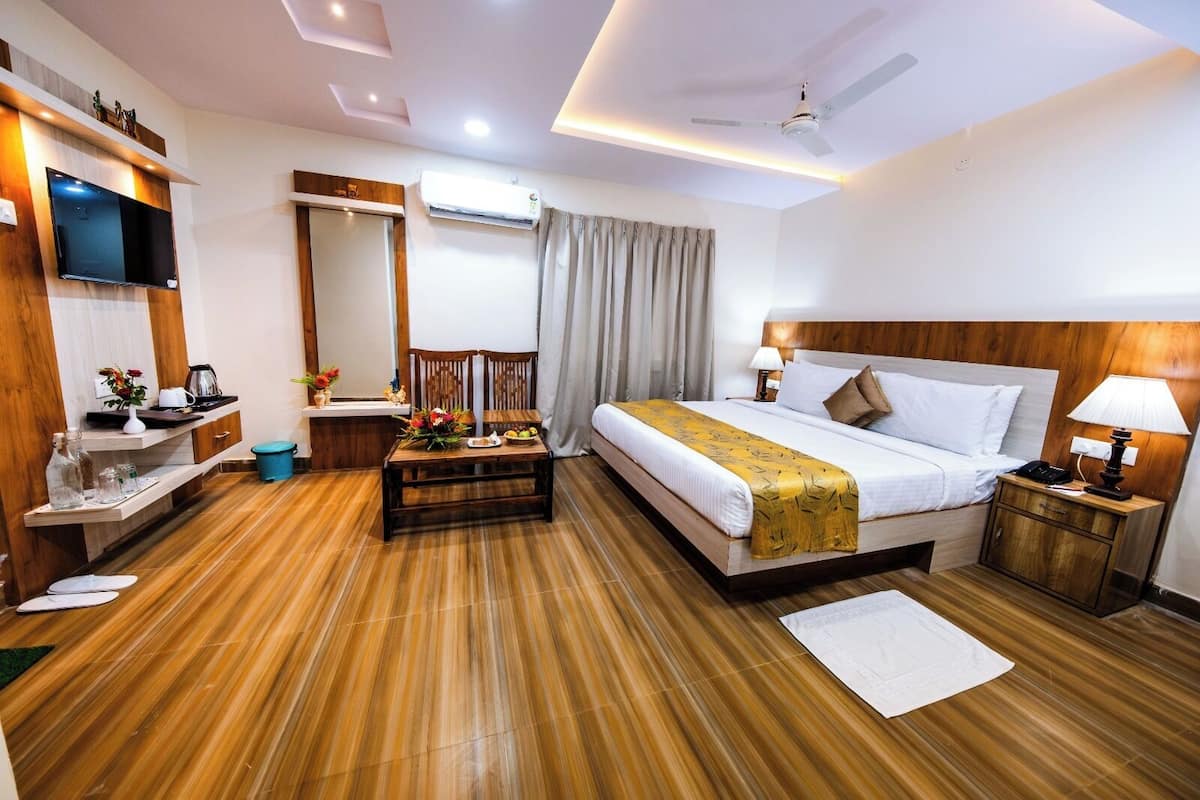 Une chambre d’hôtel comprenant un lit, des tables de chevet, une télévision, un bureau et une chaise.