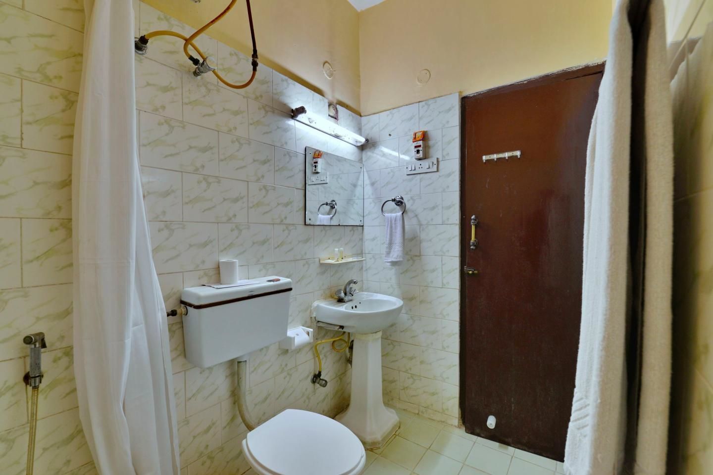 Une salle de bain comprenant des toilettes, un lavabo et un espace douche.