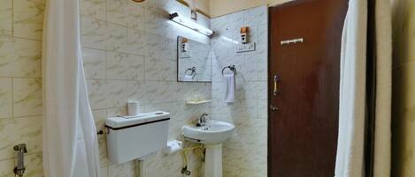 Une salle de bain comprenant des toilettes, un lavabo et un espace douche.