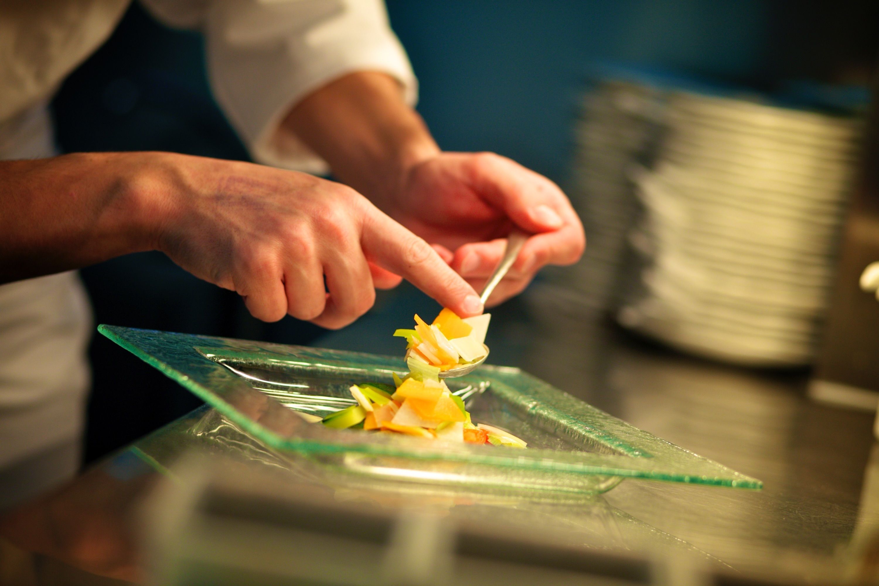 Iemand bereidt eten op een glazen bord.