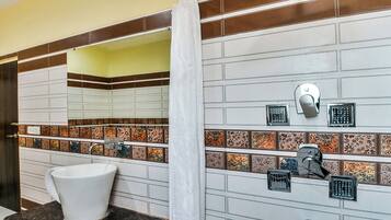 Een badkamer met een wit wastafel, een spiegel en een douchegordijn.