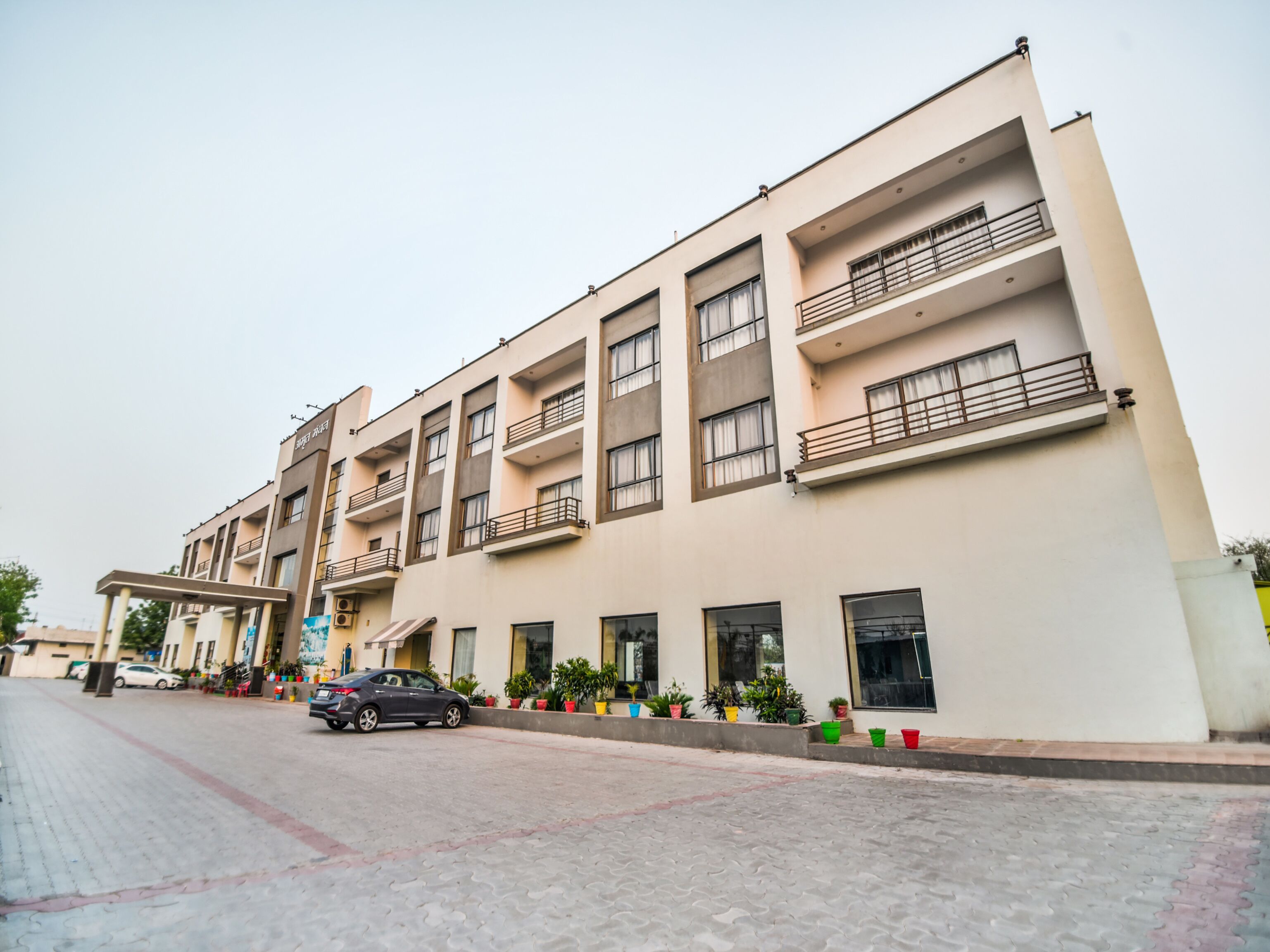 A multi-story hotel with a flat facade, balconies, and a covered entrance area.