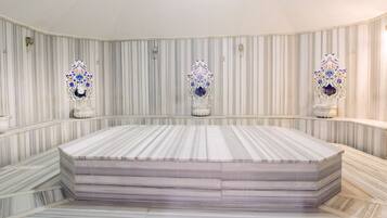 Relax in a serene space with a large, rectangular bed centered on a platform, surrounded by elegant wall decor.