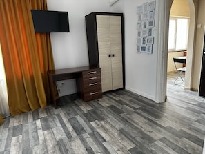A room with a desk, wardrobe, and a wall-mounted TV. - Casa Mendeleev (Bucharest)