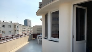 A balcony with a white railing, a table, and chairs. - Casa Mendeleev (Bucharest)