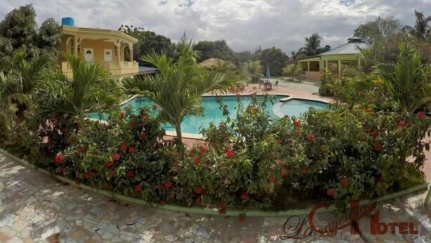 Zona de piscina con vista despejada a un edificio al fondo.