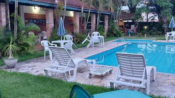 A poolside area with lounge chairs and a swimming pool.