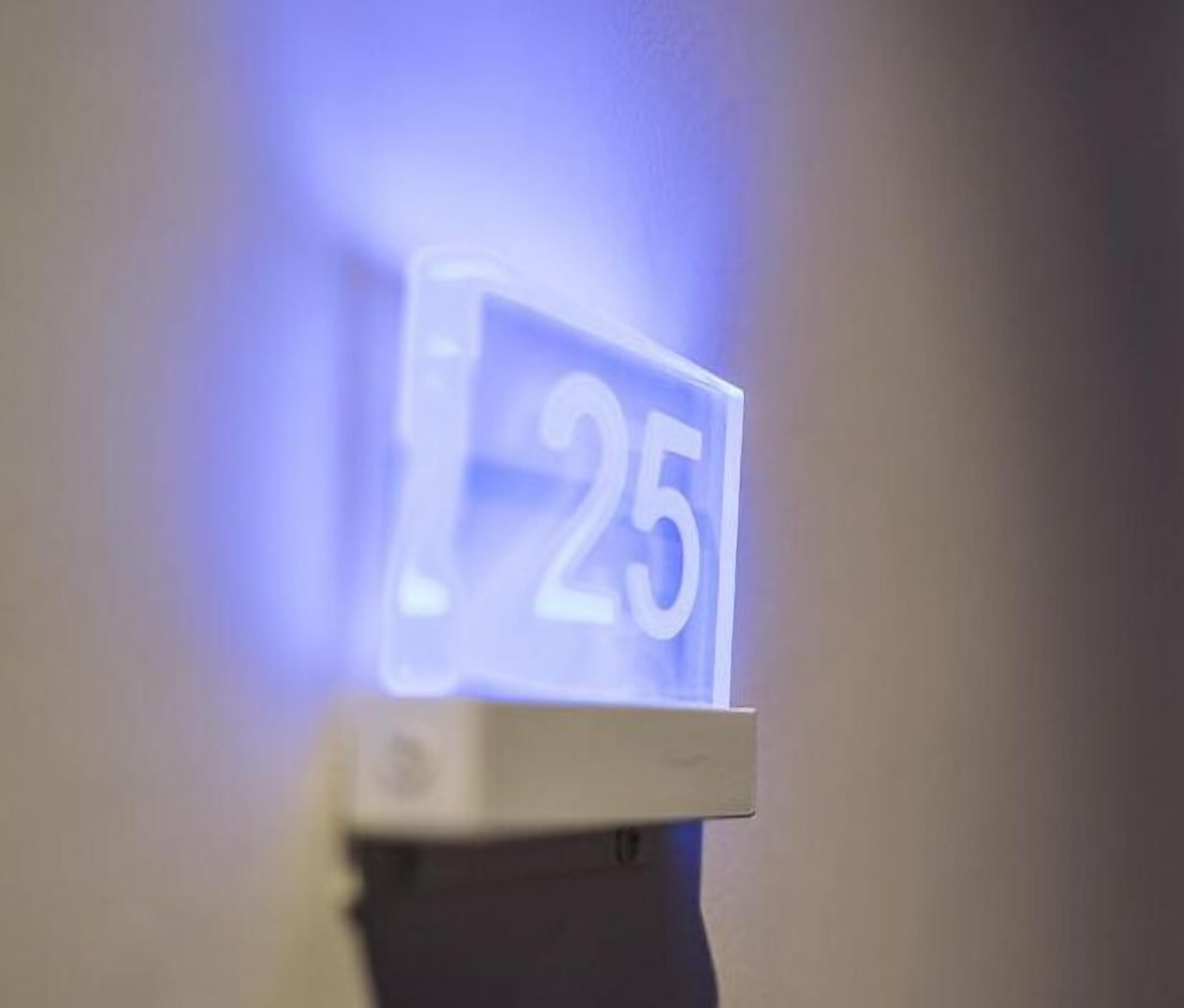 A wall-mounted digital display with the number 25.