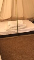 Una cama con ropa de cama blanca y una colcha doblada con cuidado.