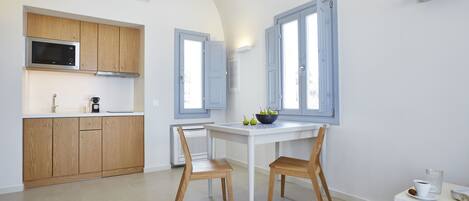 Una cocina moderna con armarios de madera, una mesa de comedor blanca y dos sillas.