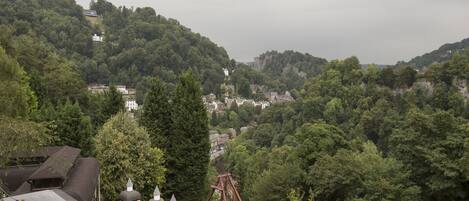 Vista de una zona montañosa con una montaña rusa y un edificio pequeño con una torre.