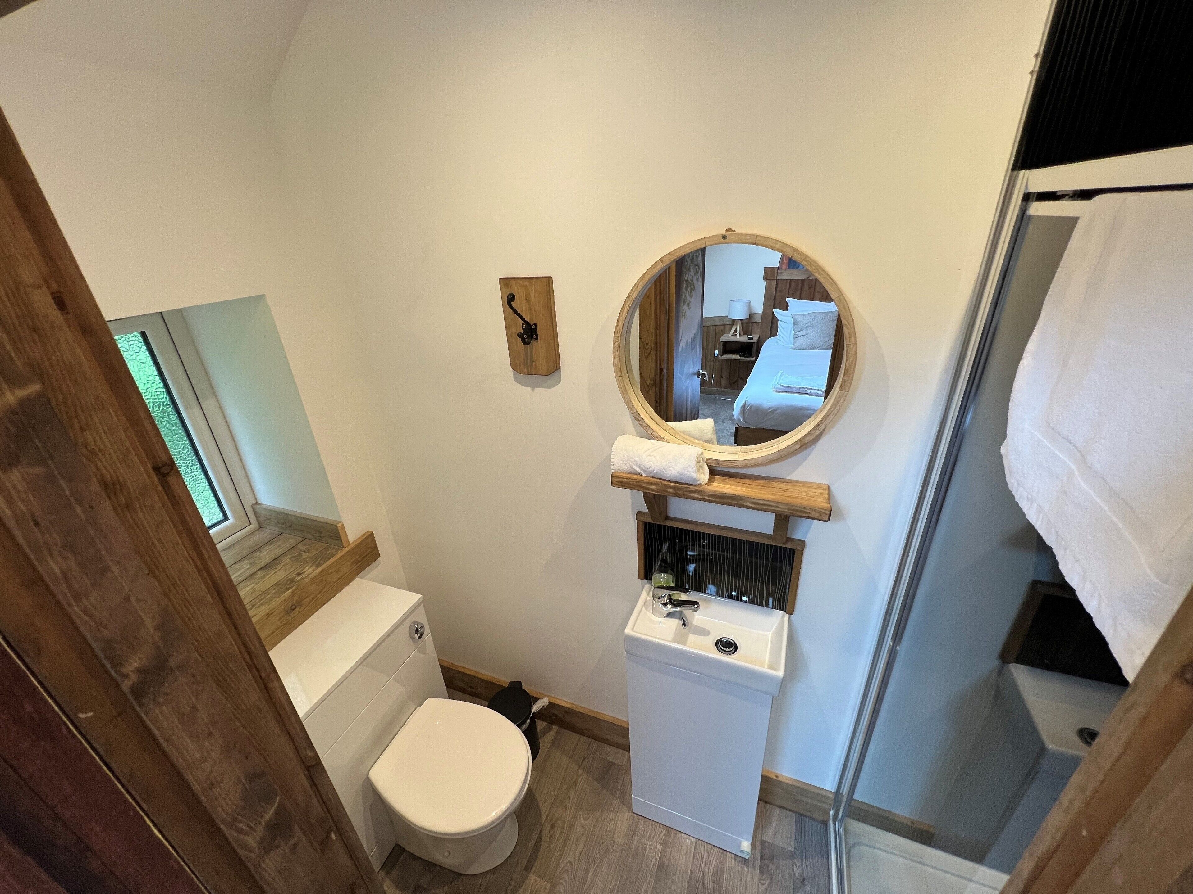 A compact bathroom with a toilet, sink, and a mirror above the sink.