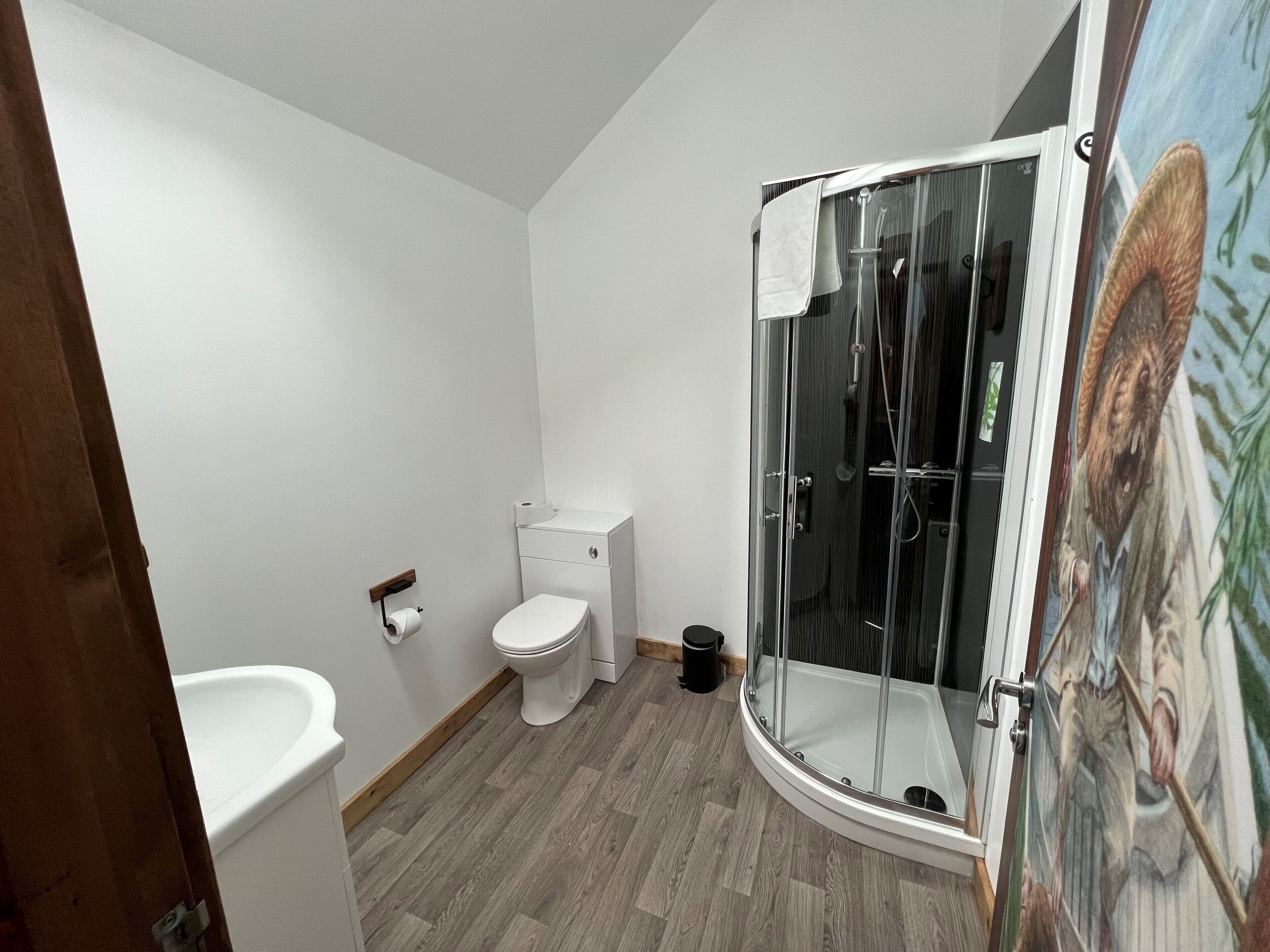 A bathroom with a toilet, a sink, and a glass-enclosed shower.