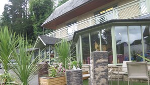 Un espace patio agrémenté d’une fontaine en pierre, de plantes en pot et de mobilier d’extérieur.