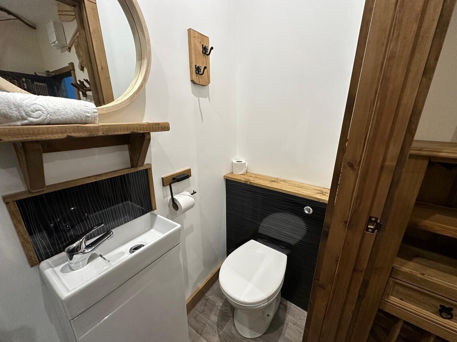 A compact bathroom with a toilet, sink, and mirror.