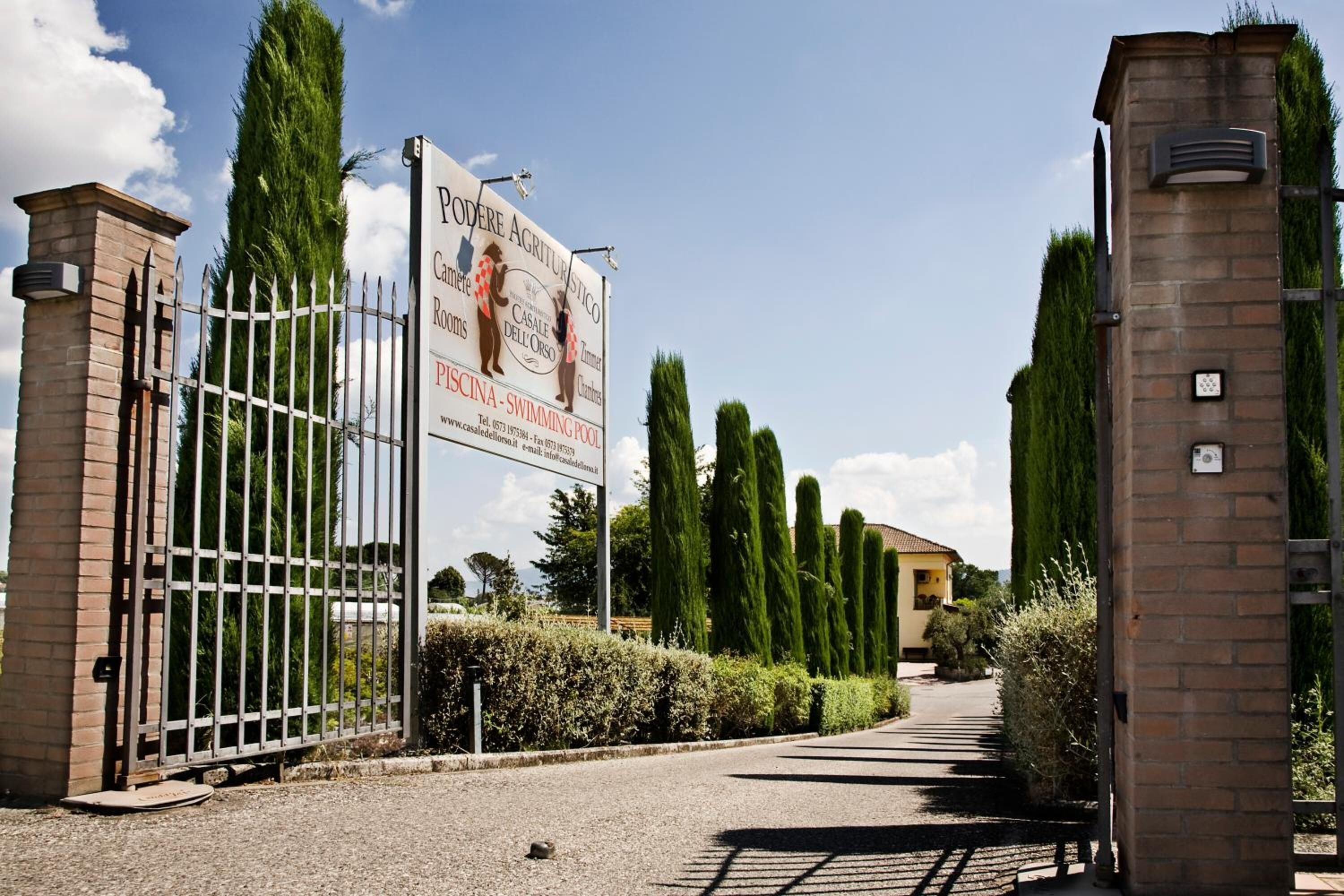A gated entrance with a sign for a swimming pool and a restaurant.