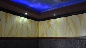 Un plafond doté d’un éclairage bleu et un mur en marbre orné d’un motif jaune et blanc.