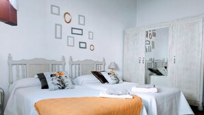 Een slaapkamer met twee bedden, een garderobe en decoratieve muurpanelen.