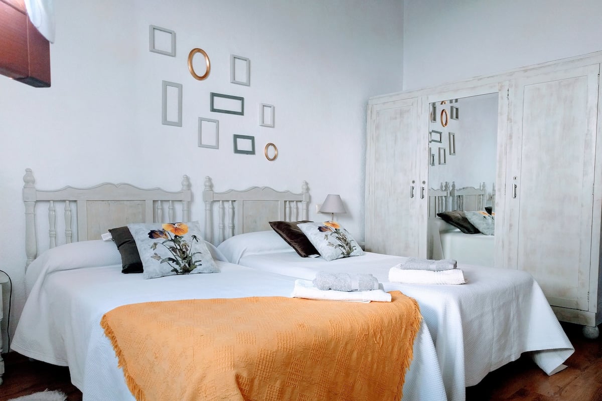 Ein Schlafzimmer mit zwei Betten, einem Kleiderschrank und Wandbildern.