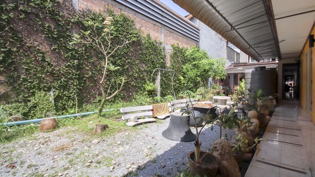 An outdoor area with a gravel path, a bench, and potted plants. - OYO 1054 Phuket Backpacker Hostel (Phuket)