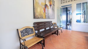 A room with a wooden bench, a large abstract painting on the wall, and a patterned wall design. - OYO 1054 Phuket Backpacker Hostel (Phuket)