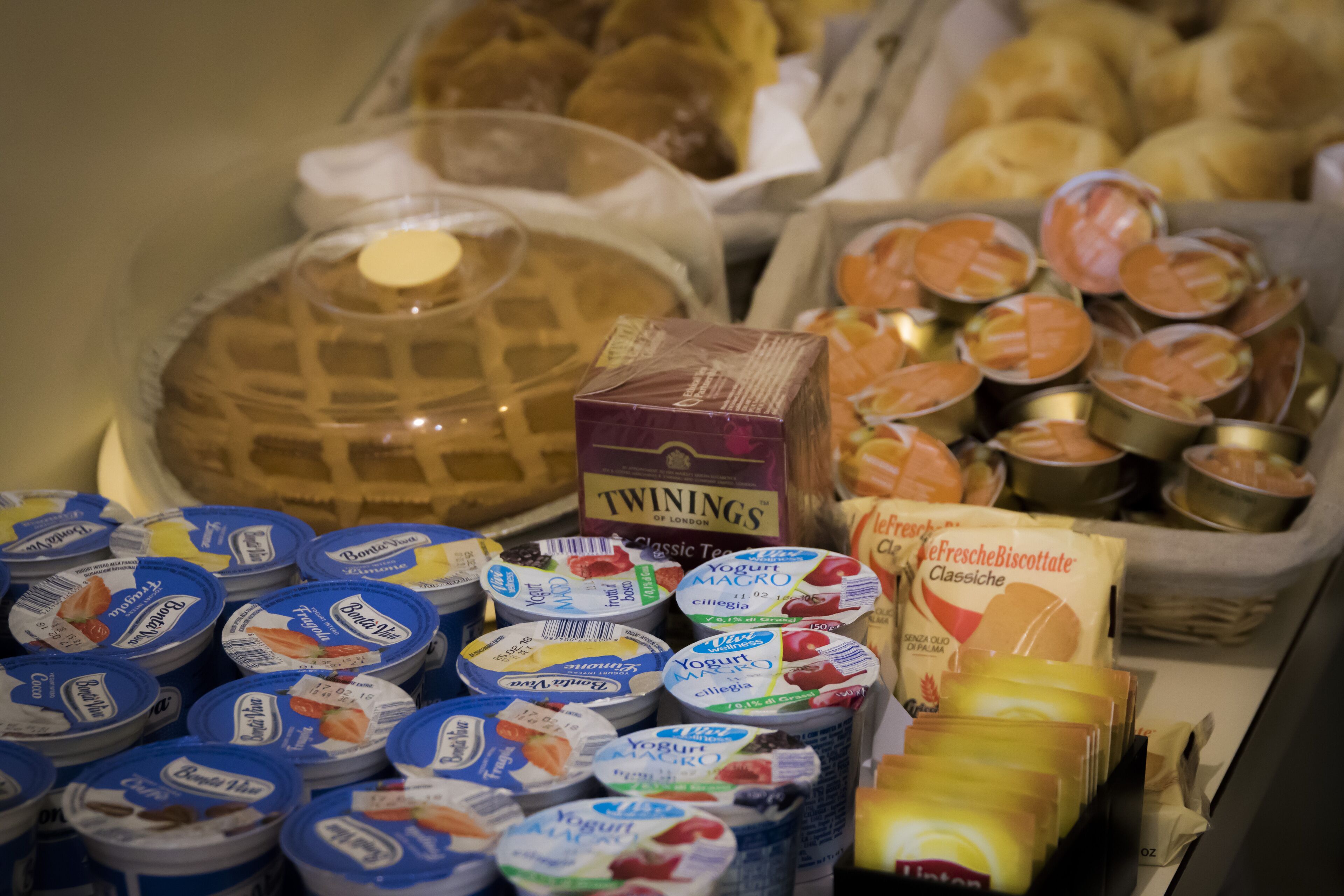 Diversos alimentos, incluyendo yogur, pastelería y una caja con la etiqueta 'TWININGS'.