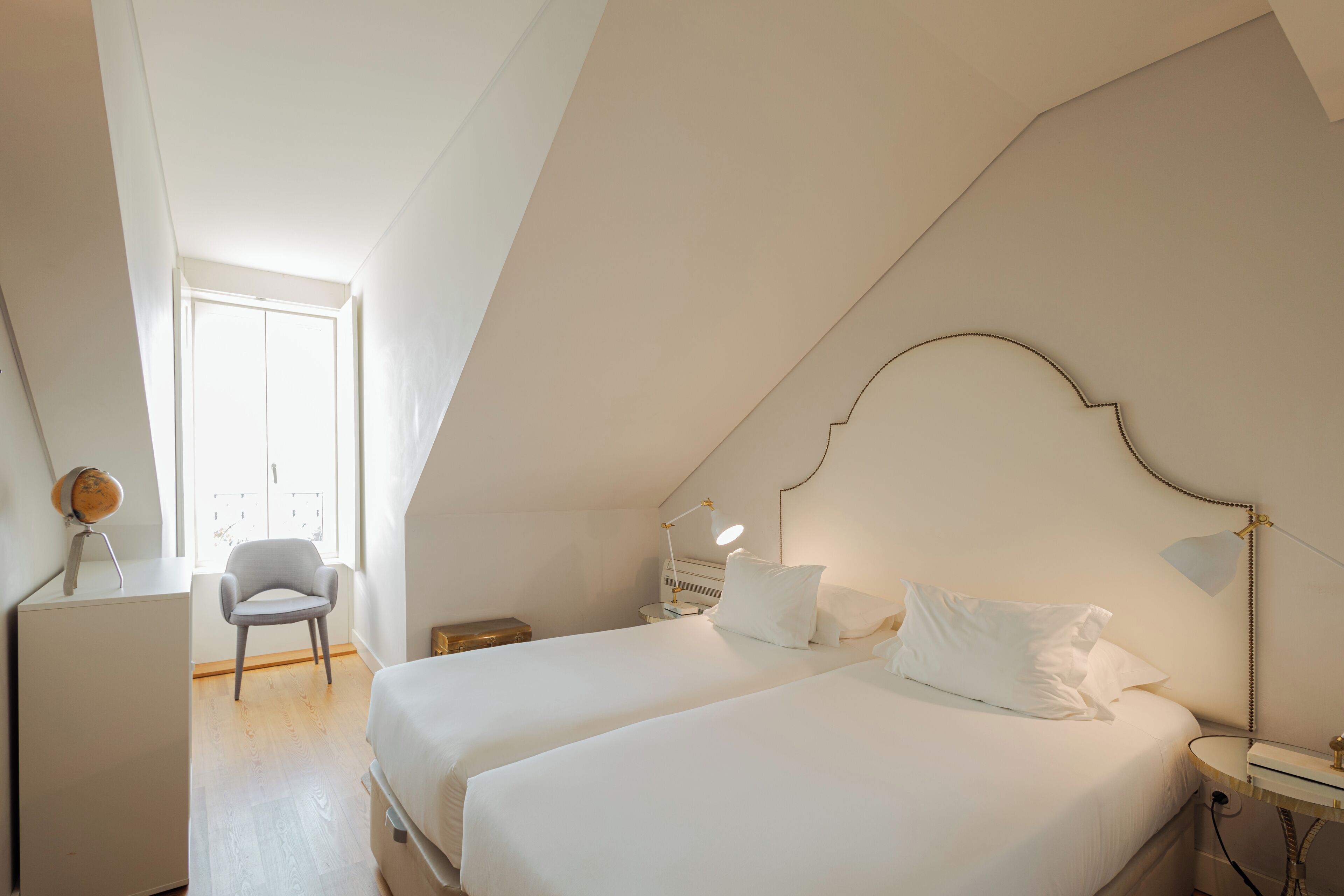 Un dormitorio con dos camas, un escritorio, una silla y una ventana.