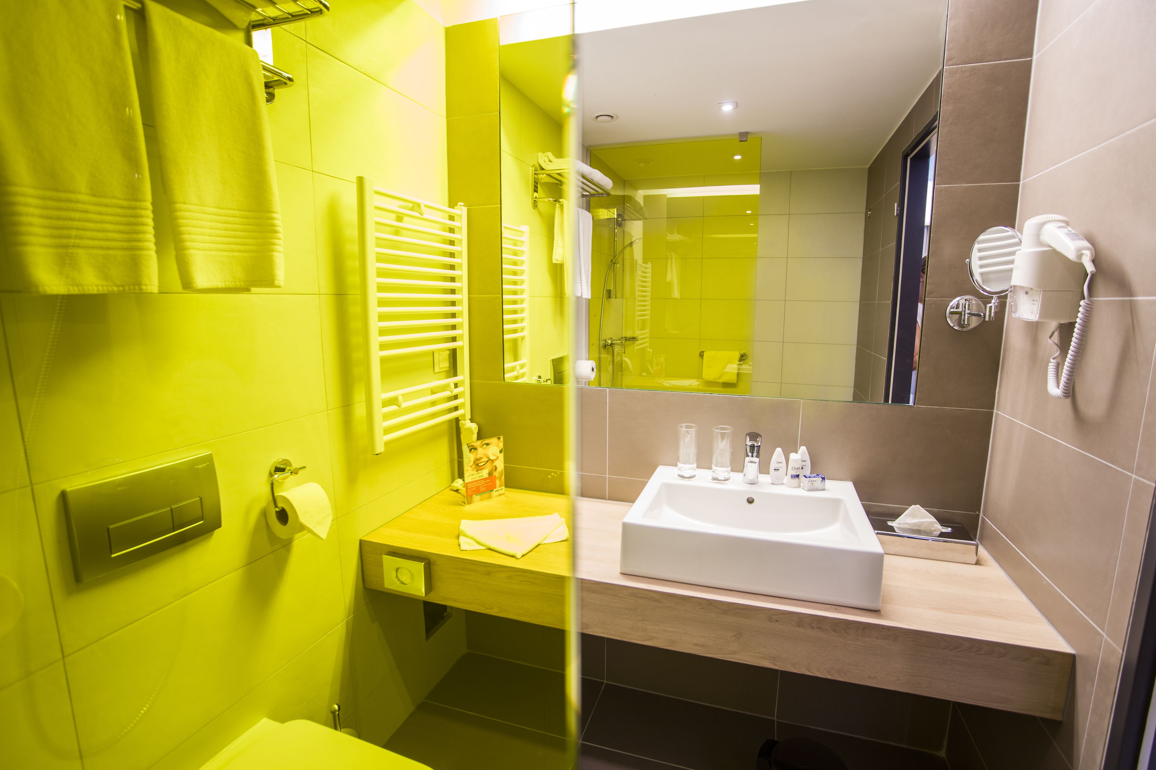 A modern bathroom with a large mirror, a sink, and a shower area.