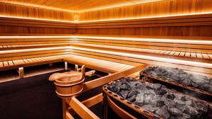 Una sauna con bancos de madera y un lavabo de piedra.
