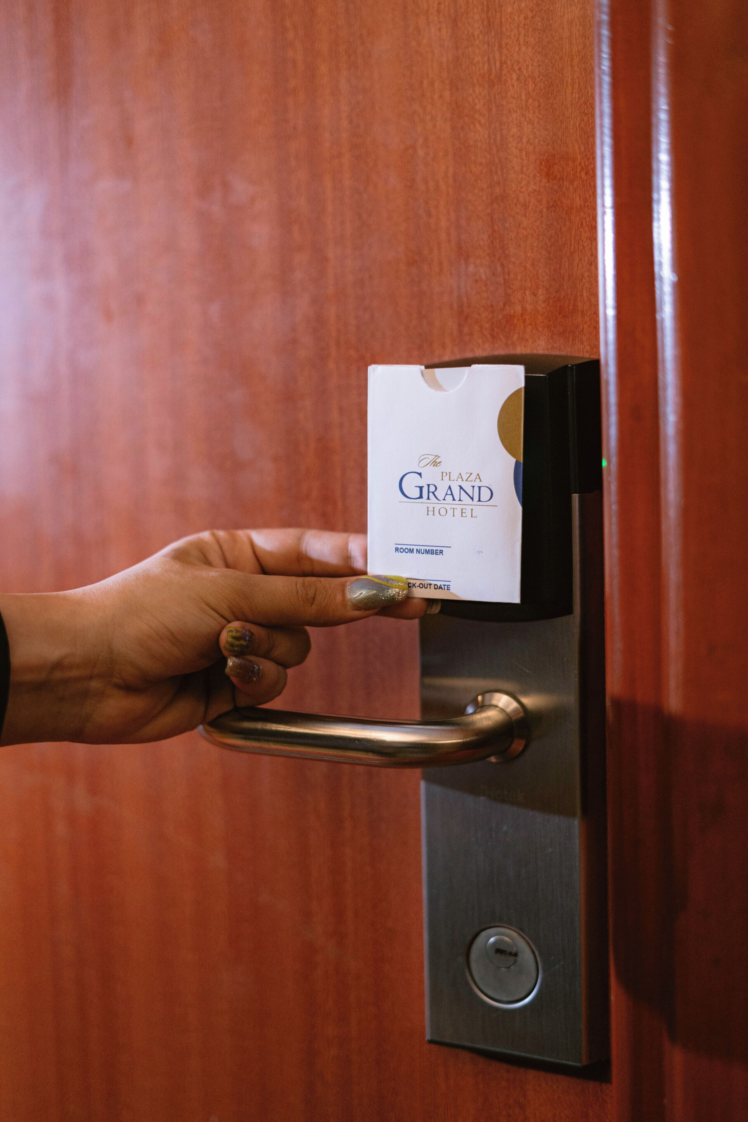 A hand inserting a key card into a keyhole on a door.