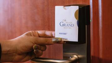 Une main insérant une carte à puce dans la serrure d’une porte.