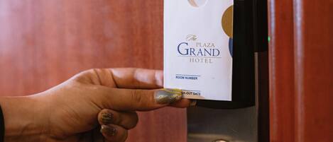 A hand inserting a key card into a keyhole on a door.