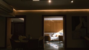 A modern interior with a dining area, a sofa, and a view into another room. - The Grand Plaza Hotel Smouha (Alexandria)