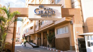 A hotel entrance with a sign reading 'The Plaza Grand Hotel,' a covered walkway, and potted plants. - The Grand Plaza Hotel Smouha (Alexandria)