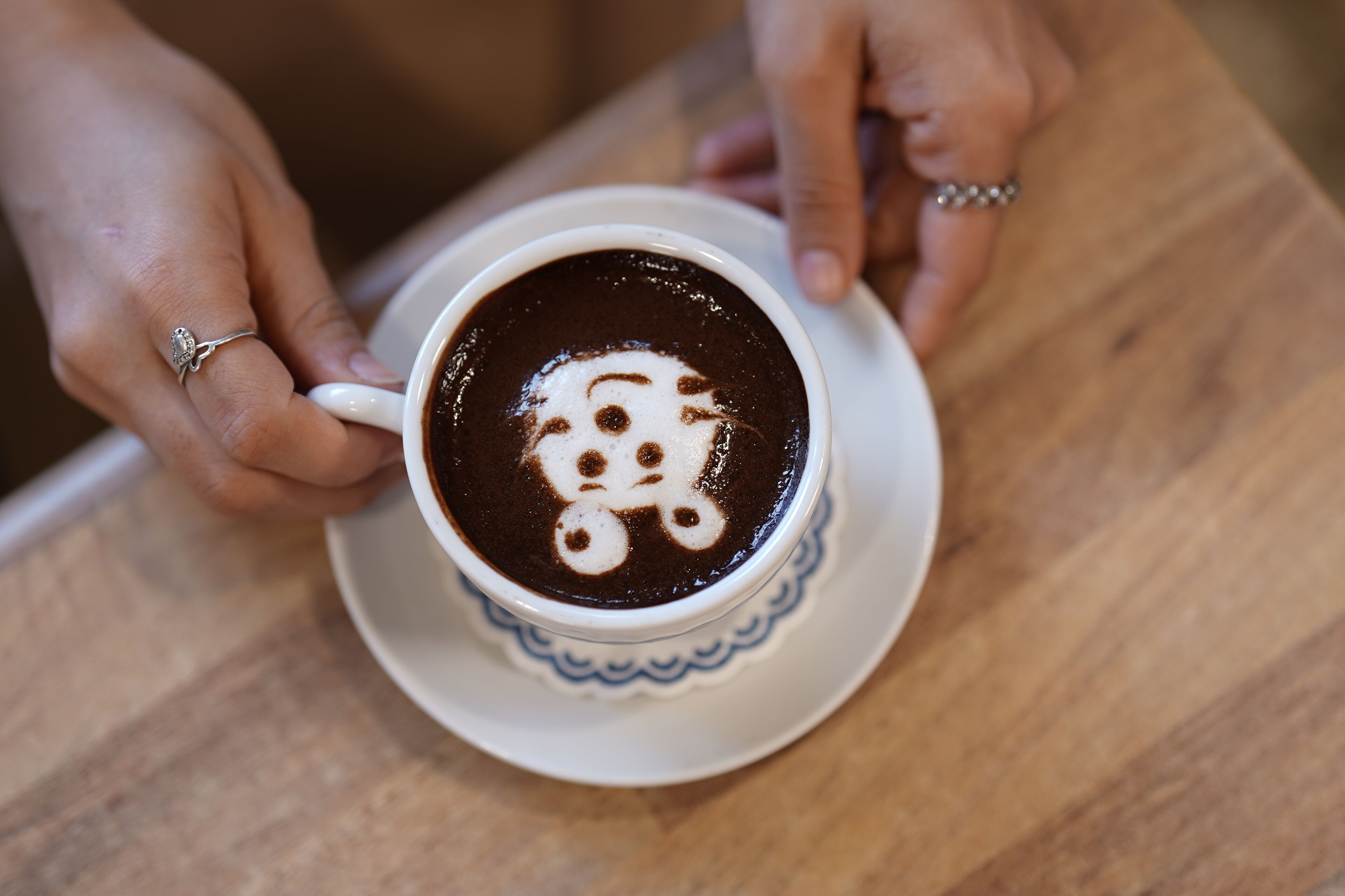 Una taza de café con arte de latte en un platito.