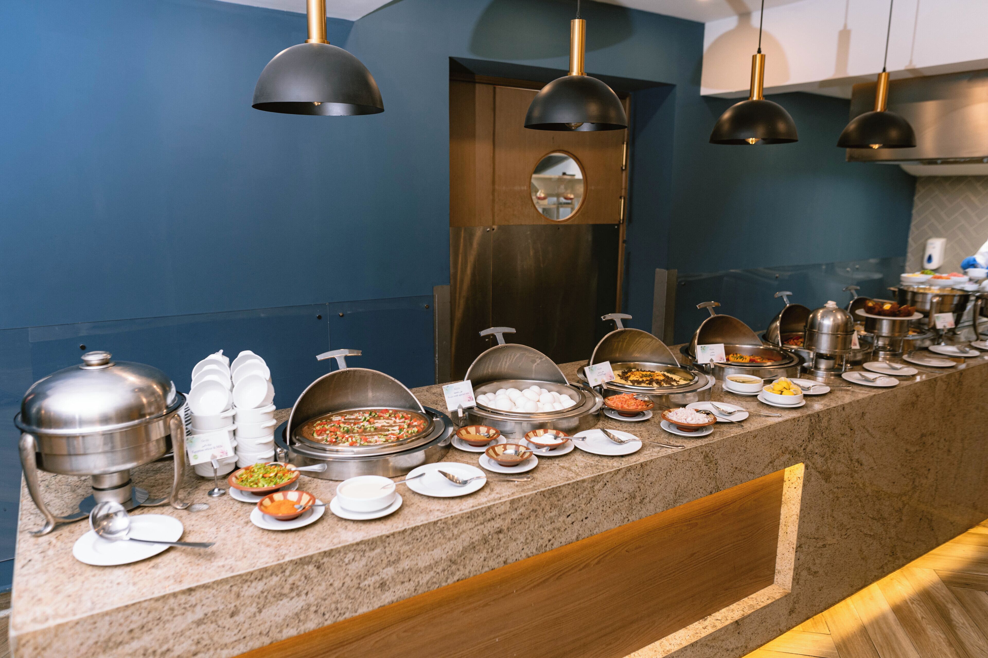 Un'area buffet con diversi contenitori per alimenti e utensili.