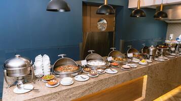 Un'area buffet con diversi contenitori per alimenti e utensili.