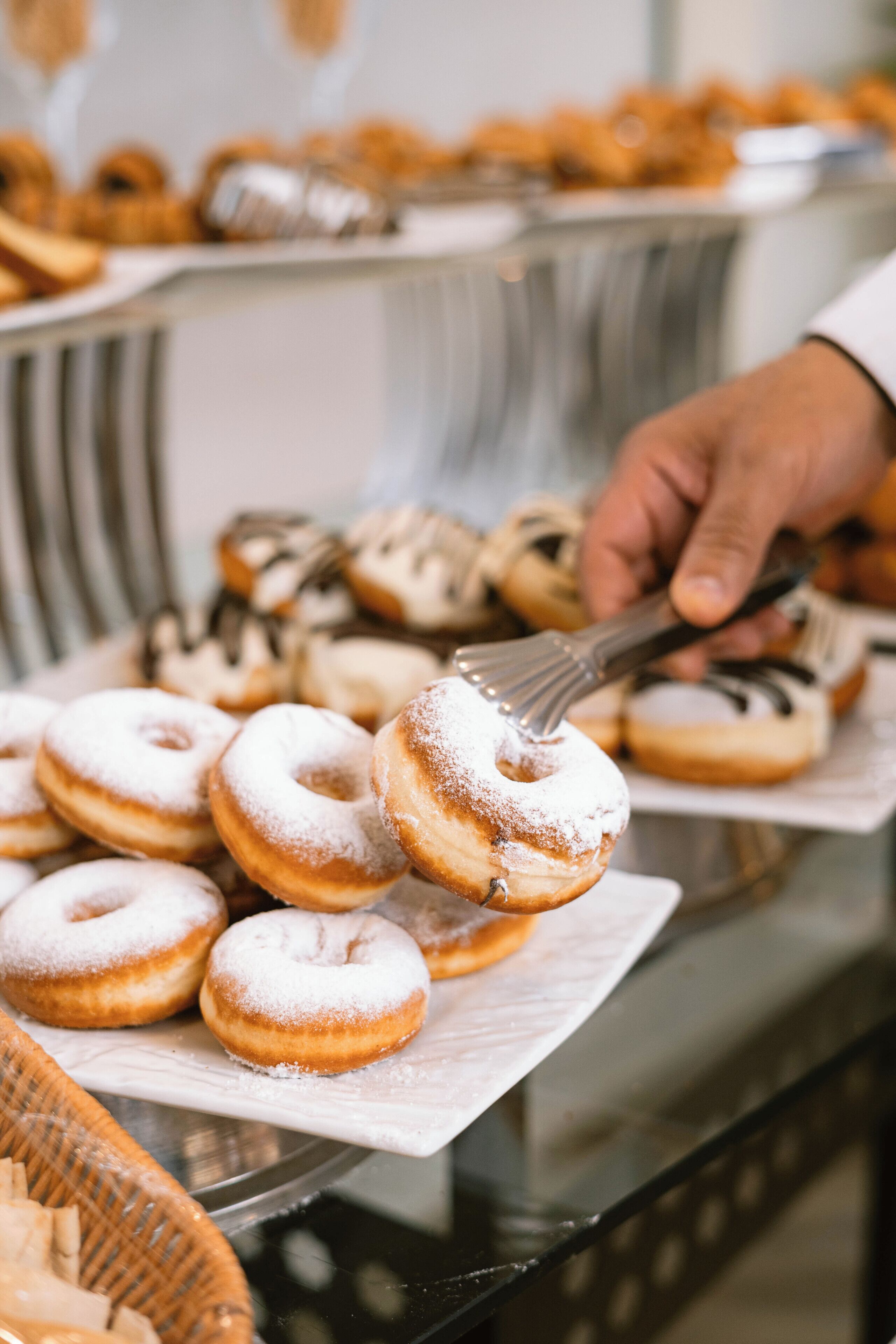 Ein Buffet mit verschiedenen Backwaren, darunter Donuts und anderem Gebäck.