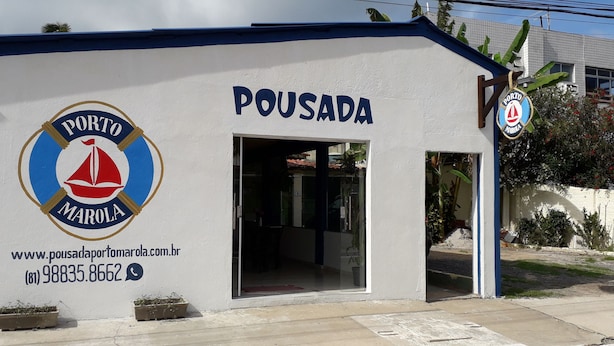 A building with a sign reading "POUSADA" and a logo for "PORTO MAROLA". - Pousada Porto Marola (Ipojuca)