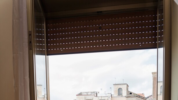 Un balcon offrant une vue sur le paysage urbain, avec des bâtiments et une rue.