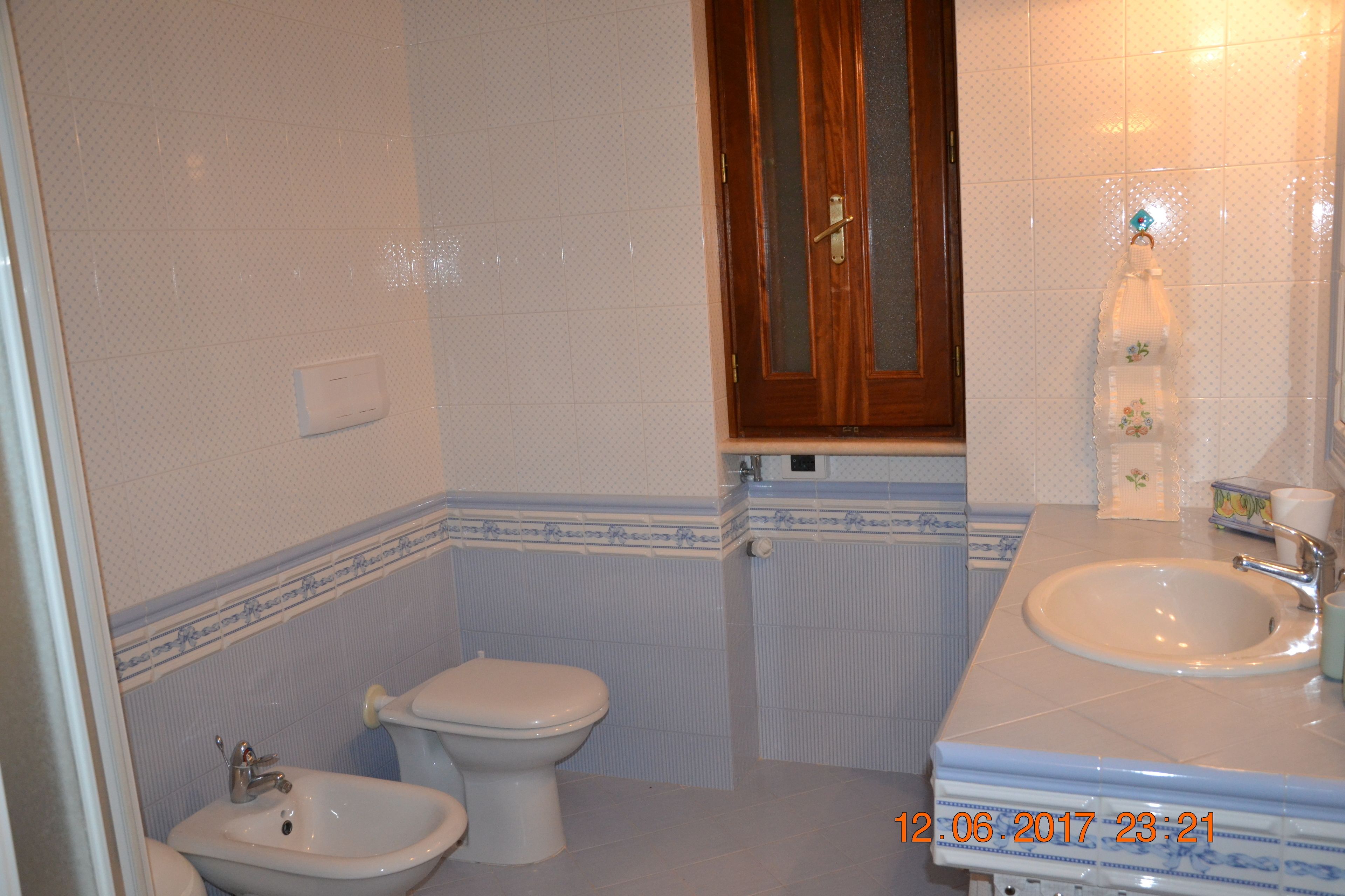 Un baño con inodoro, bidé y lavamanos.