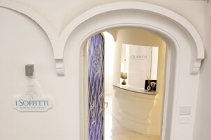 Un área de recepción de hotel con un letrero que dice "I SOFFITTI DIMORA ESCLUSIVA".