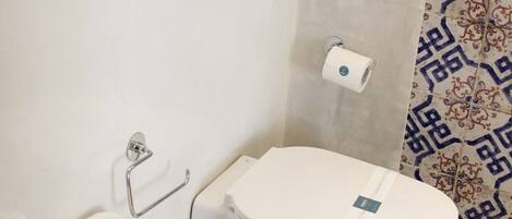 A bathroom with a white sink, toilet, and a towel rack.
