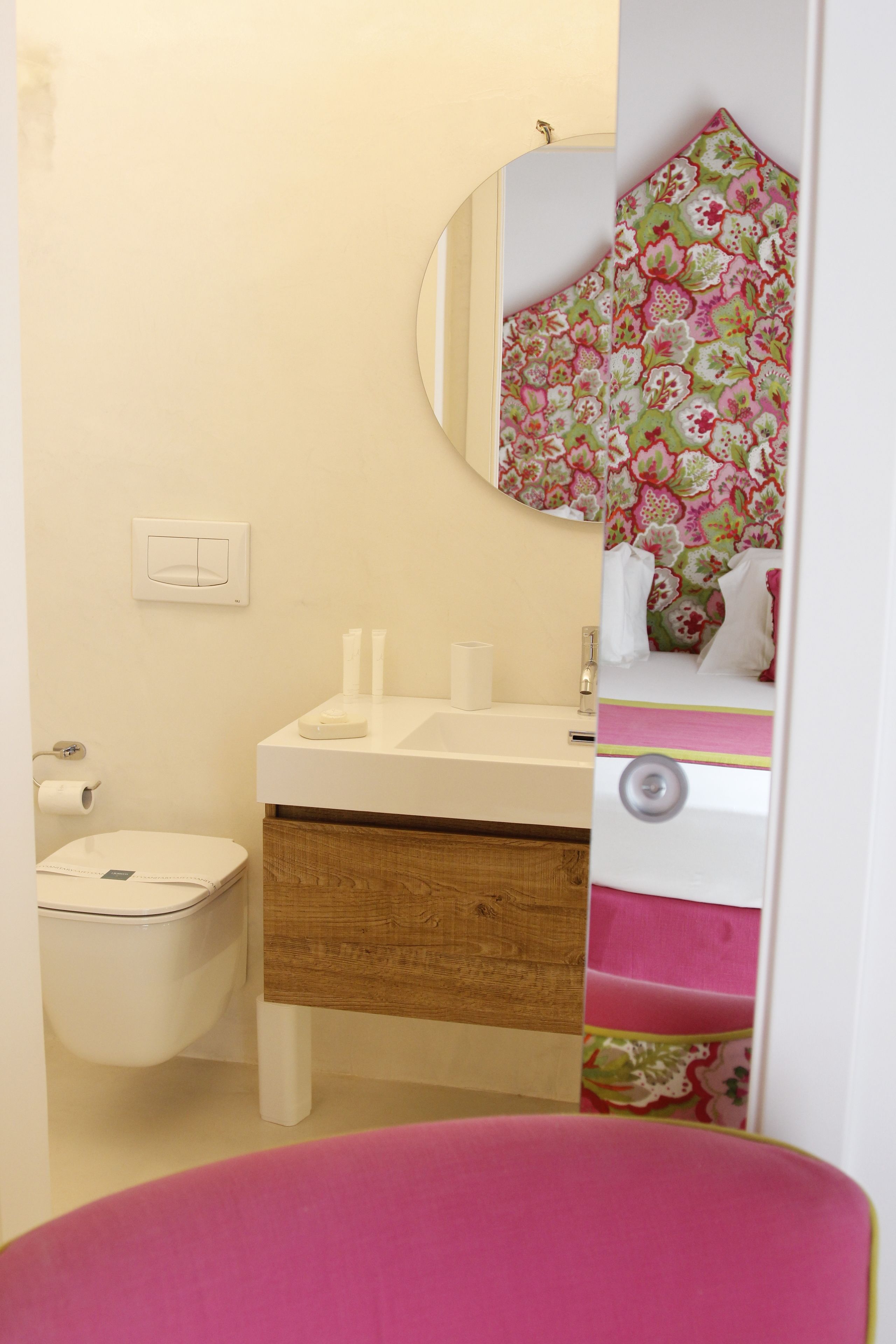 Un baño con lavamanos blanco, espejo y retrete.
