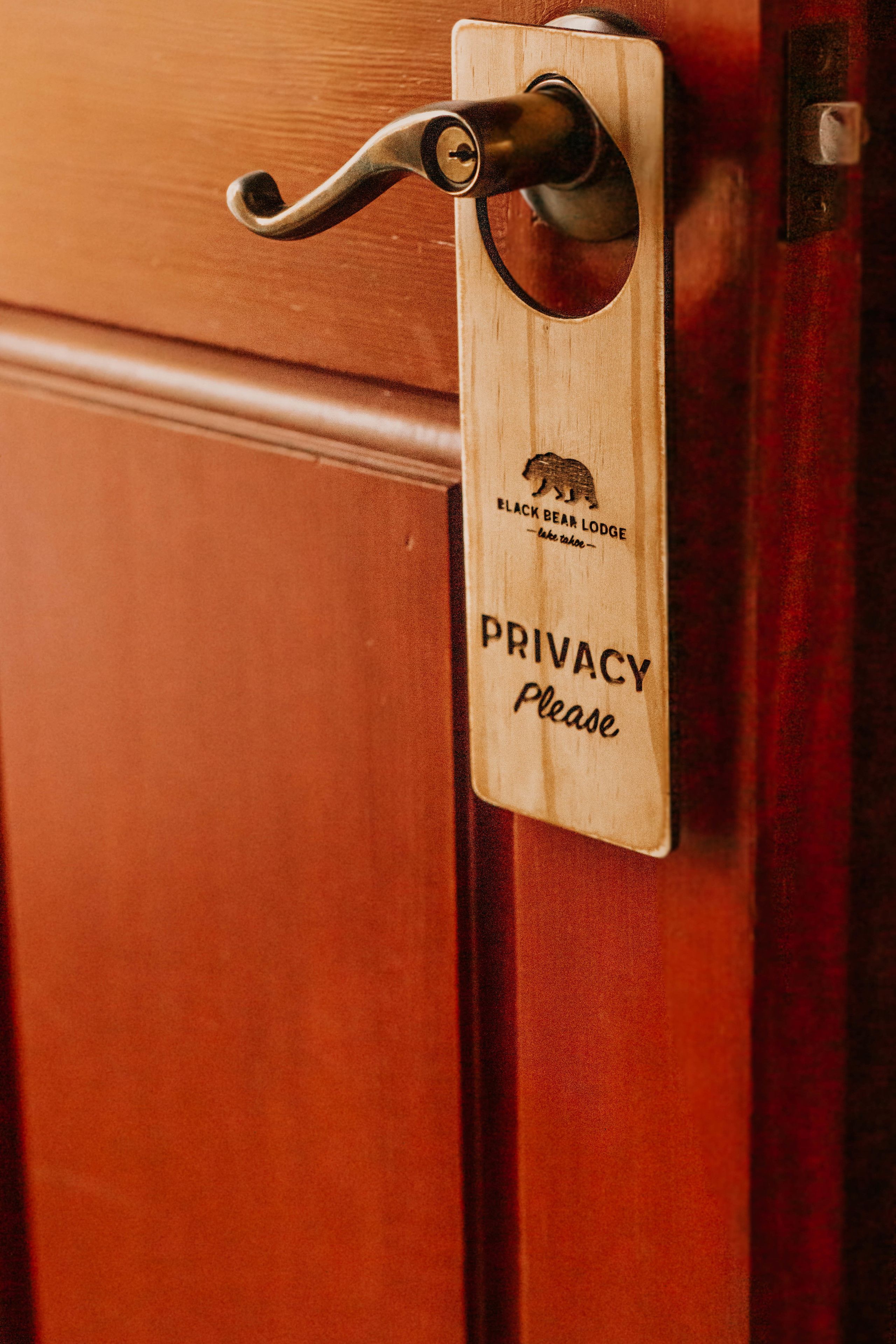 A wooden door with a privacy sign and a keyhole.
