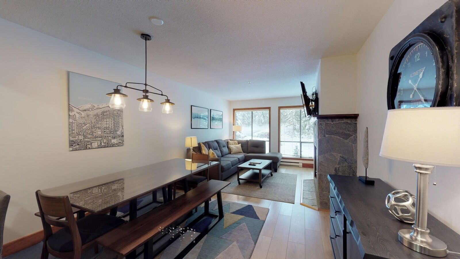 A modern living room with a dining area, a fireplace, and a large window.