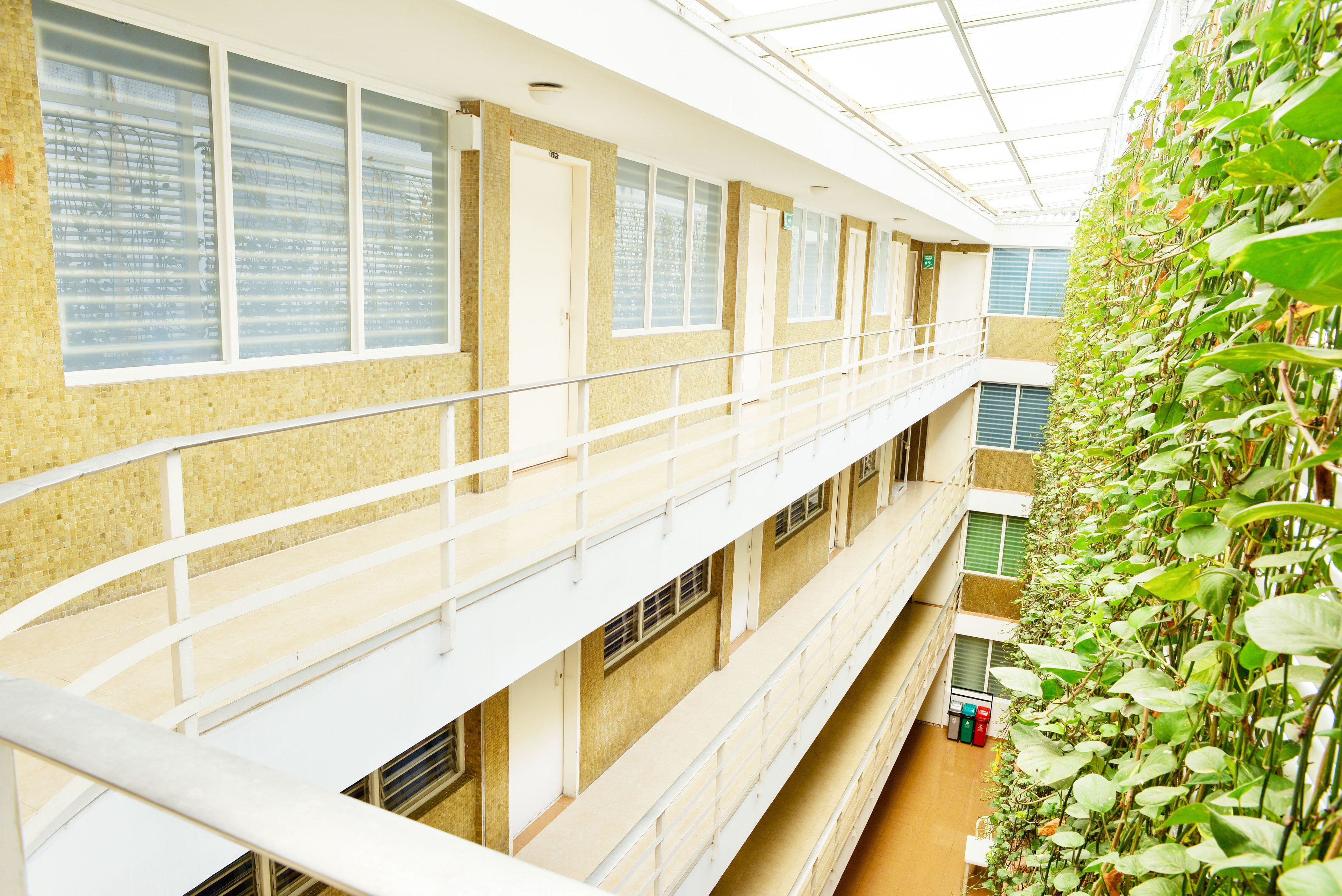 Een meerlaags atrium met een balkon, grote ramen en een verticale tuin.