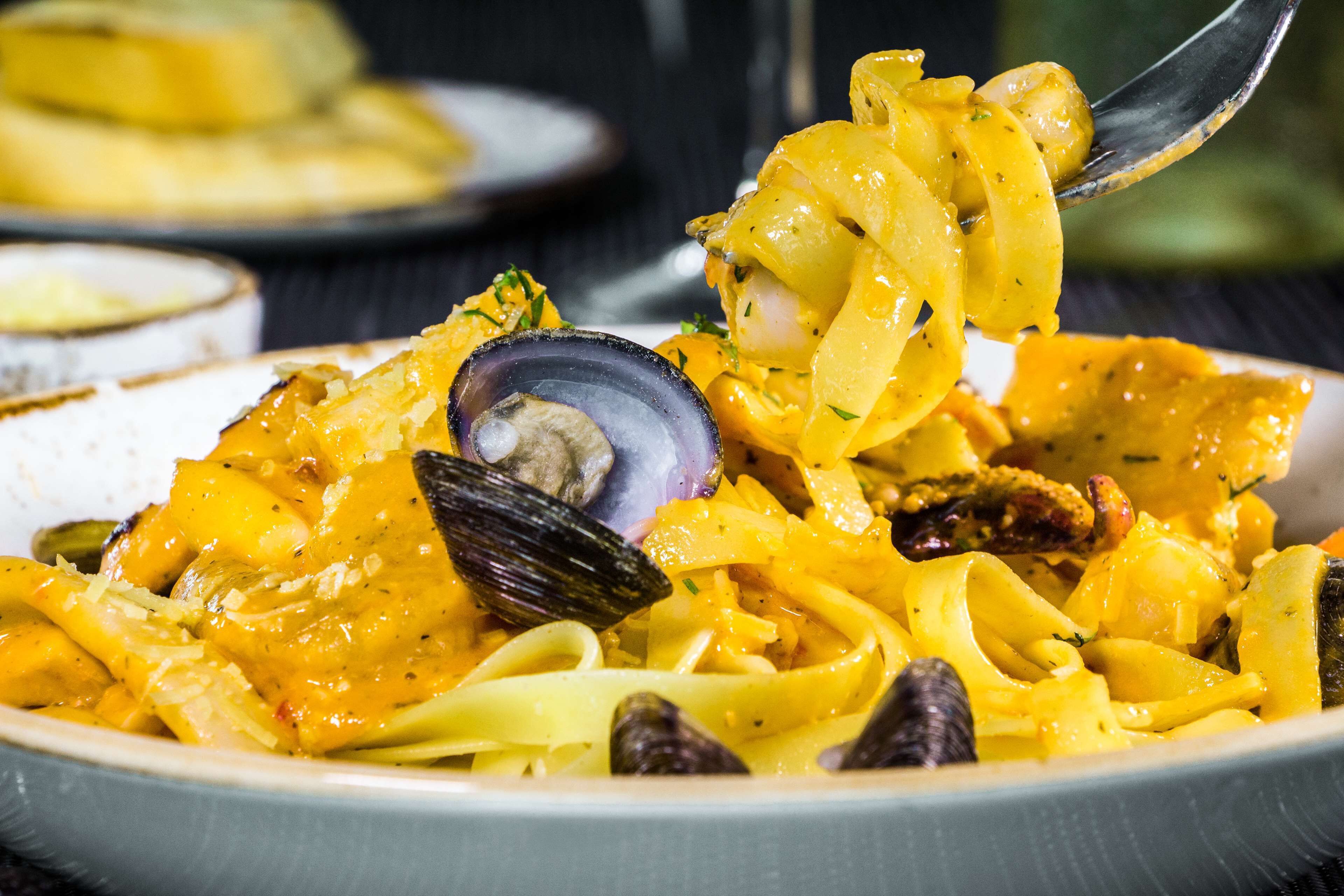 A bowl of pasta with clams and vegetables.