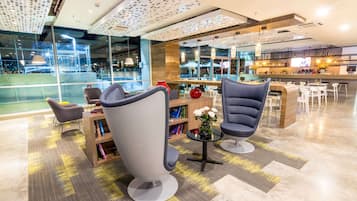 Un interior moderno con asientos, una zona de bar y grandes ventanales que ofrecen vistas al exterior.