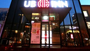 Un edificio con un llamativo letrero de UB Inn en la entrada.